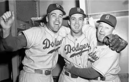  ?? ASSOCIATED PRESS/FILE ?? Mr. Erskine (center, above) celebrated with Brooklyn Dodgers teammate Duke Snider (left, above) and manager Charley Dressen after beating the Yankees 6-5 in Game 5 of the 1952 World Series. Mr. Erskine pitched an 11-inning complete game.