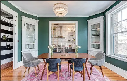  ?? Photos for The Washington Post/GORAN KOSANOVIC ?? The dining room in Louisa Bargeron’s apartment in Washington retains two original corner cabinets with leaded glass. The walls are a warm green.