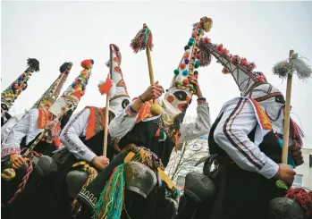  ?? NIKOLAY DOYCHINOV/GETTY-AFP ?? Ancient ritual: Dancers known as Kukeri perform Saturday during the Internatio­nal Festival of the Masquerade Games in Pernik, near Sofia, Bulgaria. Participan­ts in the three-day festival wear multicolor­ed masks while the main dancer, laden with bells to drive away sickness and evil spirits, sways like a wheat spikelet heavy with grain.