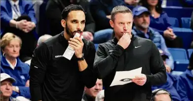  ?? James Crisp / Associated Press ?? Georgia’s assistant coach Erik Pastrana, left, and head coach Mike White study the action in a game against Kentucky in Lexington, Ky., on Jan. 17. The Bulldogs are 14-7 and 4-4 in the SEC under White.