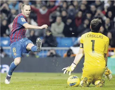  ?? AP ?? In this file photo from Saturday, December 10, 2011, FC Barcelona’s Andrés Iniesta (left) faces Real Madrid goalkeeper Iker Casillas during their Spanish La Liga match at the Santiago Bernabeu stadium in Madrid, Spain.