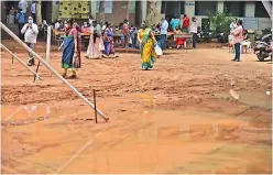  ?? — S. SURENDER REDDY ?? Beneficiar­ies face difficulty in reaching the registrati­on counter to get Covid vaccine as rainwater clogged the premises at the Musheeraba­d Government school in Hyderabad, on Monday.