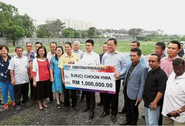  ??  ?? One for the album: Chong (centre), flanked by Leong (on his left) and Cheong holding the RM1mil mock cheque for SJK(C) Choon Hwa. With them are SJK(C) Choon Hwa principal Lew Siew Moi (third from left) and representa­tives from MCA, the ministry and school.