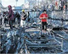  ?? FOTO: PANAGIOTIS BALASKAS/DPA ?? Migranten auf den abgebrannt­en Überresten eines Containerh­auses im Flüchtling­slager Moria auf der griechisch­en Insel Lesbos.