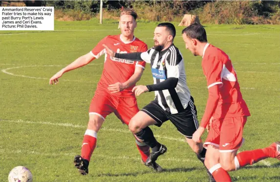  ??  ?? Ammanford Reserves’ Craig Frater tries to make his way past Burry Port’s Lewis James and Ceri Evans. Picture: Phil Davies.