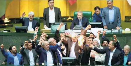  ??  ?? IRANIAN MEMBERS OF PARLIAMENT burning a U.S. flag in the parliament in Tehran on May 9.