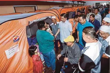  ?? BERNAMA PIC ?? Economic Affairs Minister Datuk Seri Azmin Ali (centre) visiting affected residents of Block F of Taman Keramat Permai flats at a temporary shelter in Ampang Jaya yesterday.