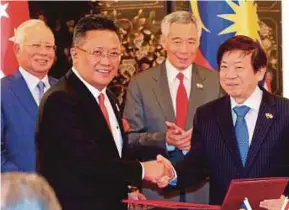  ?? PIC BY ZAIN AHMED ?? Prime Minister Datuk Seri Najib Razak and his counterpar­t, Lee Hsien Loong, witnessing the exchange of documents on the Rapid Transit System between Minister in the Prime Minister’s Department Datuk Seri Abdul Rahman Dahlan (left) and Singapore’s...