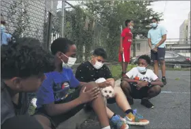  ?? JESSIE WARDARSKI — ASSOCIATED PRESS ?? St. Francis Xavier students sit together for the first time in five months after their school was closed due to the coronaviru­s pandemic, Thursday, Aug. 6, 2020, in Newark. The students and their concerned families gathered at the school to discuss its permanent closure, announced by the Archdioces­e of Newark the previous week.