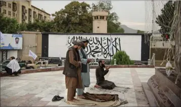  ?? KIANA HAYERI — THE NEW YORK TIMES ?? Taliban fighters pray in Masood Square, just outside Kabul’s Green Zone, and in front of what used to be the American embassy last August.