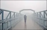  ?? AMAL KS/HT PHOTO ?? ■
A man on a foot overbridge near IIT in New Delhi on Monday morning.