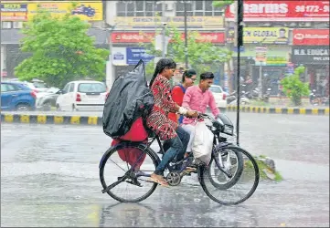  ?? SAMEER SEHGAL/HT ?? Commuters making their way through rain in Amritsar on Saturday.