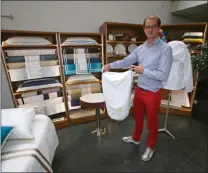  ??  ?? Loïc Derville, le patron de Victoria Yachting, présente un exemple de linge de maison individual­isé.