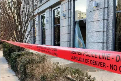  ?? Photograph: Colleen Slevin/AP ?? Police tape blocks the damage to large windows at the Colorado supreme court on 2 January in Denver.