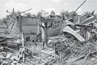  ?? RUPAK DE CHOWDHURI/REUTERS ?? A man carries a tin sheet salvaged from the rubble of his damaged house in the aftermath of cyclone Amphan in the eastern state of West Bengal, India, Friday.