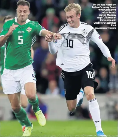  ?? WILLIAM CHERRY/PRESSEYE ?? On the run: Northern Ireland’s Jonny Evans with Germany’s
Julian Brandt during Monday night’s European
Championsh­ip Qualifier at Windsor
Park