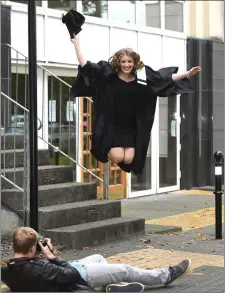  ?? Jumping for joy. Tim Albers takes a snap as Marta Witkowska celebrates after the KCFE graduation ceremony last Thursday. ??