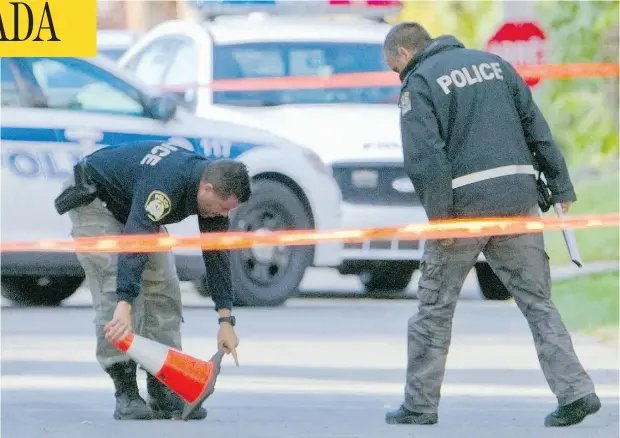  ?? PHIL CARPENTER / MONTREAL GAZETTE ?? Laval police survey the scene near where the body of a 19-year-old man was found allegedly bludgeoned to death by a man wielding a hammer.