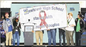  ?? Chip Somodevill­a / Getty Images ?? Newtown High School students present a banner to survivors of the Marjory Stoneman Douglas High School during the March for Our Lives rally on Saturday in Washington, D.C.