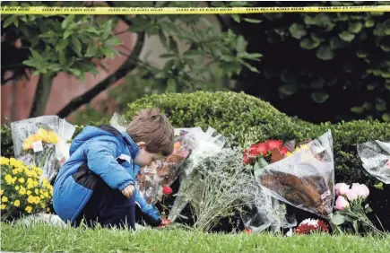  ??  ?? Gideon Murphy places a flower at the Tree of Life Synagogue in Pittsburgh, Sunday, Oct. 28, 2018.