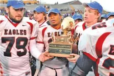  ?? STAFF PHOTO BY ROBIN RUDD ?? From left, Signal Mountain football players Will Sawyer, Gervell Morgan and Hogan Whitmire carry the TSSAA Class 2A state championsh­ip trophy off the field after the Eagles beat Trinity Christian 56-28 in December 2010 in Cookeville.