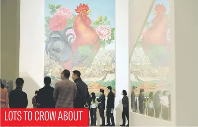  ?? Picture:Reuters ?? Visitors in front of a painting, Big Rooster, by Chinese artist Lv Shengzhong during an exhibition at China Central Academy of Fine Arts in Beijing yesterday.
