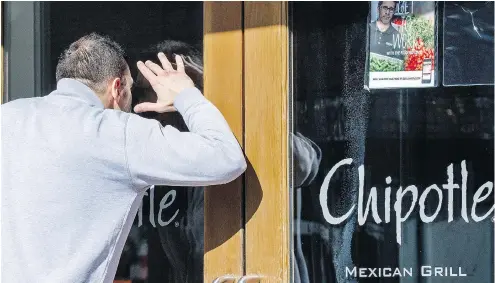  ?? PAUL J. RICHARDS / AFP / GETTY IMAGES FILES ?? A customer peers into a locked Chipotle when the chain temporaril­y closed its doors in 2016 to educate 60,000 employees about the food-borne illnesses that had rocked the company in previous months. Food safety protocols were also explained in the meeting.