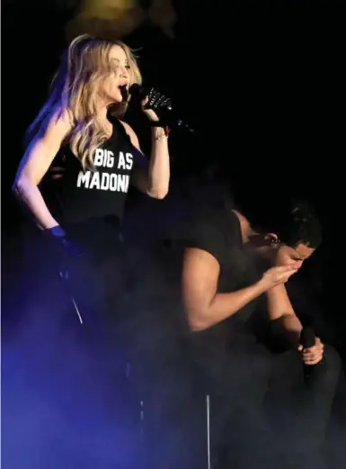 ?? CHRISTOPHE­R POLK/GETTY IMAGES ?? Drake reacts in apparent disgust after Madonna leans in for a long smooch at Coachella festival in Indio, Calif., on Sunday.