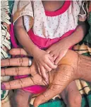 ??  ?? Abeba Gebru holds her baby daughter’s hands