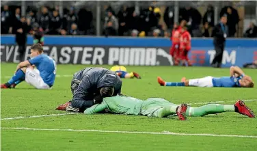  ?? PHOTOS: GETTY IMAGES ?? As the Swedish team celebrates, left, Italy players slump to the ground in despair after a 0-0 stalemate in Milan meant the Azzurri failed to qualify for the World Cup for the first time in 59 years.