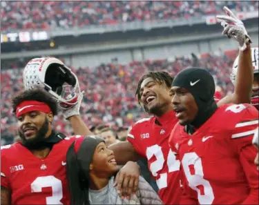  ?? JAY LAPRETE - THE ASSOCIATED PRESS ?? Ohio State’s Damon Arnette, left to right, Shaun Wade, and Kendall Sheffield celebrate with fans after beating Michigan in an NCAA college football game Saturday, Nov. 24, 2018, in Columbus, Ohio. Ohio State beat Michigan 62-39.