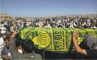  ?? Rahmat Gul / Associated Press ?? Men carry the coffin of a relative during his funeral in the capital, Kabul. Afghans mourned the loss of family members, friends and colleagues, a day after a bomb killed 90 people.