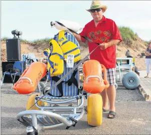  ?? CAPE BRETON POST ?? Raymond MacLean explains some of the features of a floating wheelchair that allows people with mobility problems get into the water at Inverness beach.