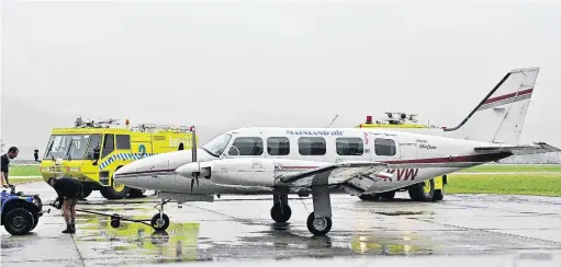  ?? PHOTOS: LINDA ROBERTSON ?? Grounded . . . Service crew at Dunedin Airport attend the Piper Chieftain which had an engine stop in midair yesterday.