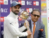  ?? — Reuters ?? India’s Virat Kohli receives the ICC Test Mace from former Indian cricket player Sunil Gavaskar (right) after India won the test series against Australia.