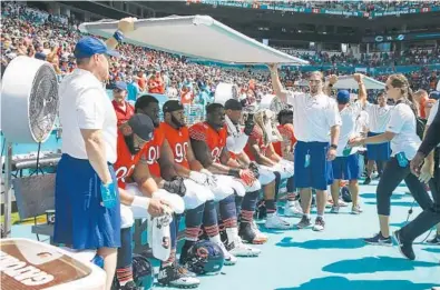  ?? JOSE M. OSORIO/CHICAGO TRIBUNE ?? Chicago Bears players try to keep cool during a game against the Miami Dolphins at Hard Rock Stadium.