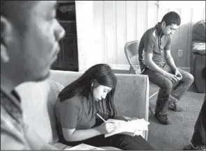  ?? AP/ KAREN PULFER FOCHT ?? Candelario Jimon Alonzo, 16, ( right) sits with his cousin, Melisa Jimon Reynoso ( center), and uncle, Domingo Jimon, in their home in Memphis, on April 21. Domingo Jimon took his nephew in after he fl ed from Guatemala.