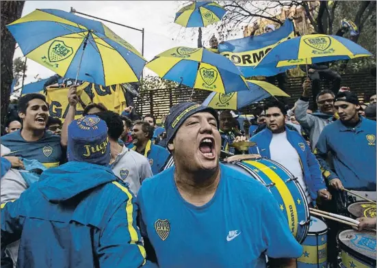  ?? PABLO BLÁZQUEZ DOMÍNGUEZ / GETTY ?? Aficionats del Boca Juniors animant els jugadors del seu equip a l’hotel de concentrac­ió ahir a Madrid