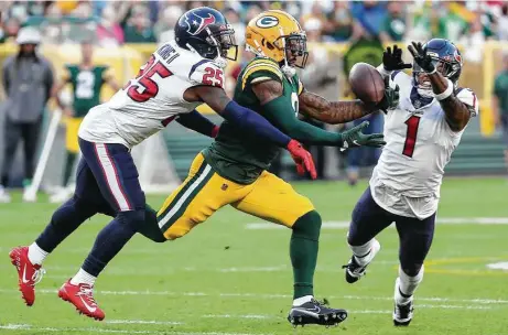  ?? Photos by Brett Coomer / Staff photograph­er ?? Texans D-backs Desmond King II and Lonnie Johnson (1) break up a preseason pass intended for Packers wideout Amari Rodgers.