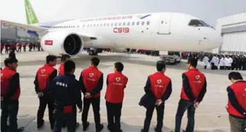  ??  ?? ... China’s first big passenger plane C919, a narrow-body jet which can seat 168 passengers, goes on display at a facility in Shanghai yesterday. The C919 rolled off the assembly line as China seeks to develop its own aviation sector and challenge...