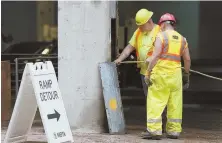  ?? STAFF PHOTO BY ANGELA ROWLINGS ?? REOPENING TODAY: Workers continue to make repairs to the Alewife MBTA garage in Cambridge yesterday.