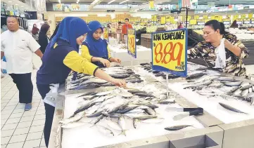  ??  ?? Mydin staff arrange fresh seafood at its Samariang branch.