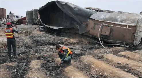  ?? IRAM ASIM / THE ASSOCIATED PRESS ?? Rescue workers examine the site of an oil tanker explosion near Bahawalpur, Pakistan on Sunday. Hundreds of nearby villagers had rushed to the scene to gather leaking fuel and were killed when the tanker exploded.