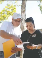  ?? NEWS-SENTINEL FILE PHOTOGRAPH ?? Charles H. Jacobs looks over papers with the chamber’s director of membership­s Marina Navarte during a job fair, organized by the Lodi Chamber of Commerce and held outside their Downtown Lodi office in 2017.
