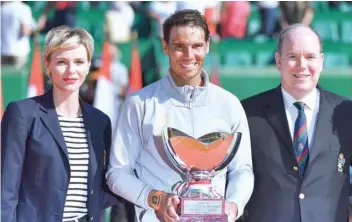  ?? — AFP ?? Princess Charlene (left) and her husband Prince’s Albert II of Monaco (right) stand with Spain’s Rafael Nadal as he holds the winner’s trophy following his win over Japan’s Kei Nishikori in their final match at the Monte-carlo ATP Masters Series.