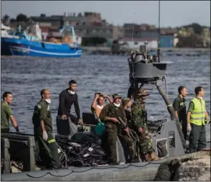  ?? The Associated Press ?? MIGRANT DEATHS: Egyptian coast guard and rescue workers bring ashore bodies recovered from a Europe-bound boat that capsized off Egypt’s Mediterran­ean coast Thursday in Rosetta, Egypt.