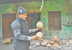  ?? BURHAAN KINU/HT PHOTO ?? ■ Fifty-two-year-old Rakhigarhi school teacher Ramesh Chandra with the old pottery, believed to be from the Harappan era, that he found in his fields.