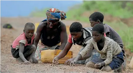  ?? AP ?? Residents of Mozambique look for stones they can sell as building materials. A New Zealander has been arrested in a loans scandal that nearly bankrupted the country, already one of the poorest nations in the world.