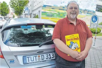  ?? FOTO: SEBASTIAN HEILEMANN ?? Dieter Kleibauer mit der Ausgabe 3 aus dem Jahr 1965. Im Straßenver­kehr ist er an seinem Kennzeiche­n mit der Nummer 313 zu erkennen - der selben, wie auf Donald Ducks Cabrio.