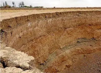  ?? AP ?? This frame grab from a video provided by Iranian Students’ News Agency, ISNA, shows the edge of a massive hole caused by drought and excessive water pumping in Kabudaraha­ng, in Hamadan province, western Iran.